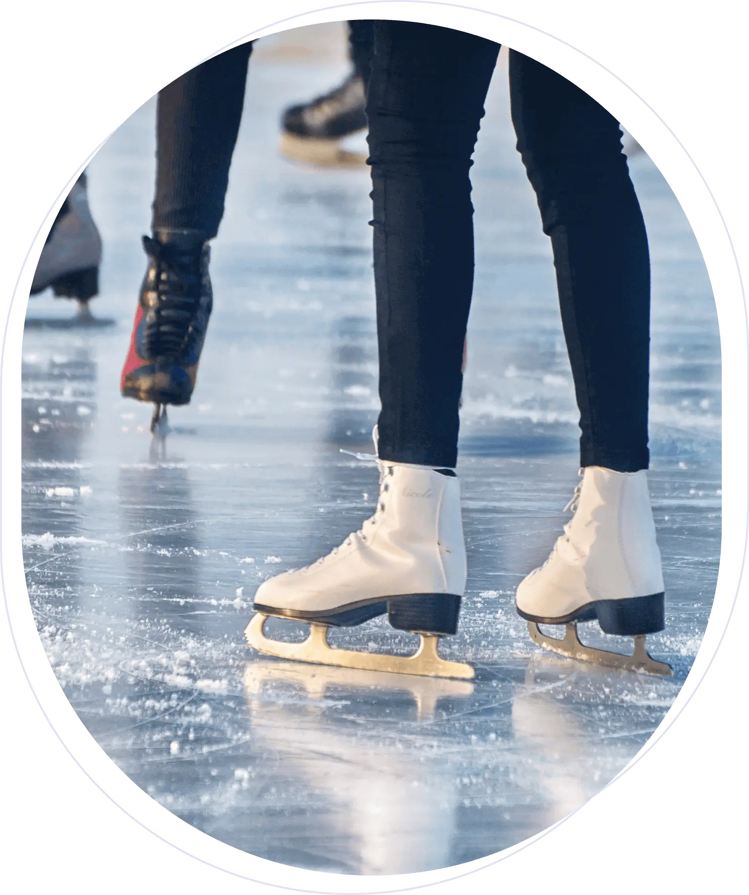 People ice skating on a rink, close-up of legs and skates, with a glossy ice surface.